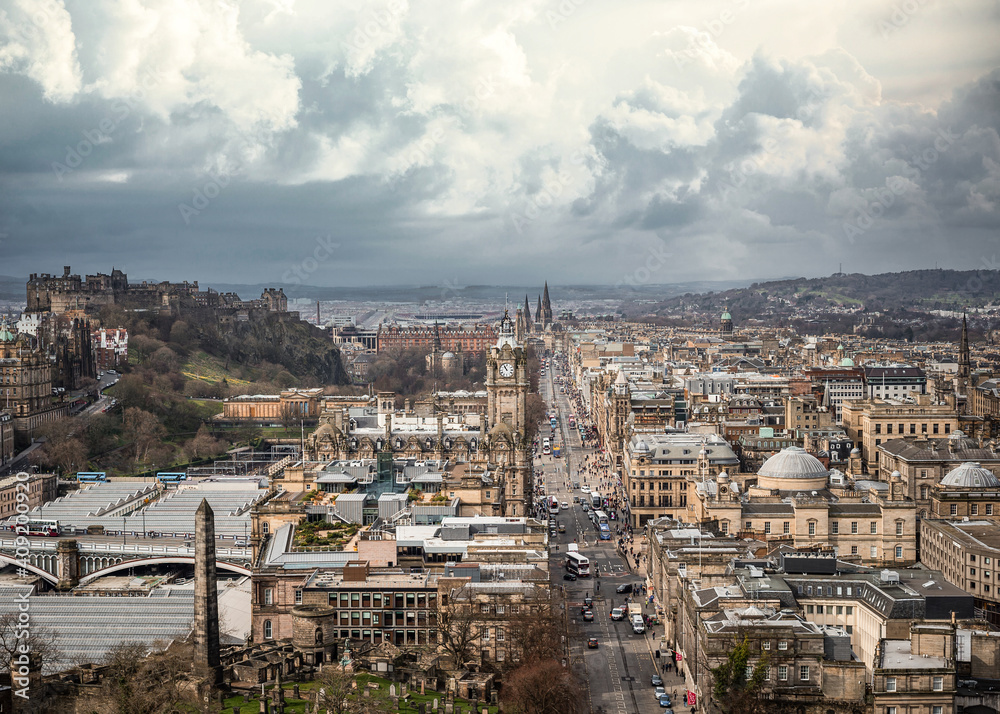 Scotland Edinburgh city centre looking down Main shopping street Street from high arial viewpoint storm clouds gathering busses over bridge town hall clock tower wide angle view panoramic cityscape