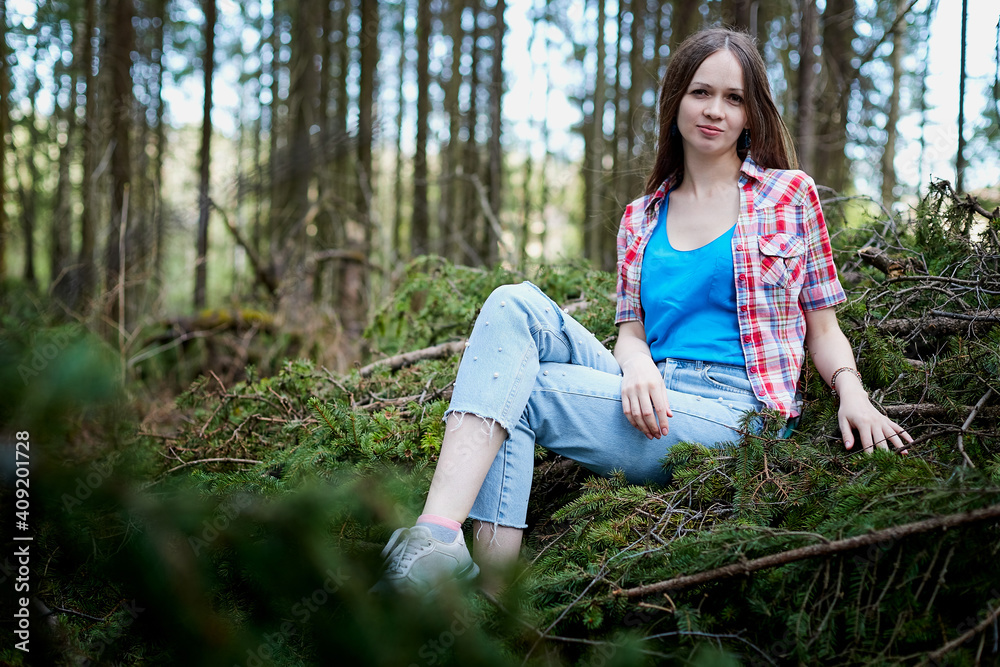 Beautiful young brunette woman with long hair in a forest pines and firs on a summer day Beautiful young brunette woman with long hair in a forest pines and firs on a summer day