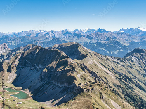 Mountains and a small mountain lake in the Bernese Oberland, seen from the Brienzer Rothorn on a sunny autumn day