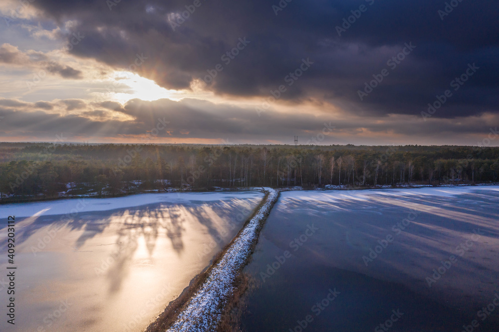 Zimowy wieczór nad stawem hodowlanym. Widok z drona. Zimowy wieczór nad stawem hodowlanym. Widok z drona.