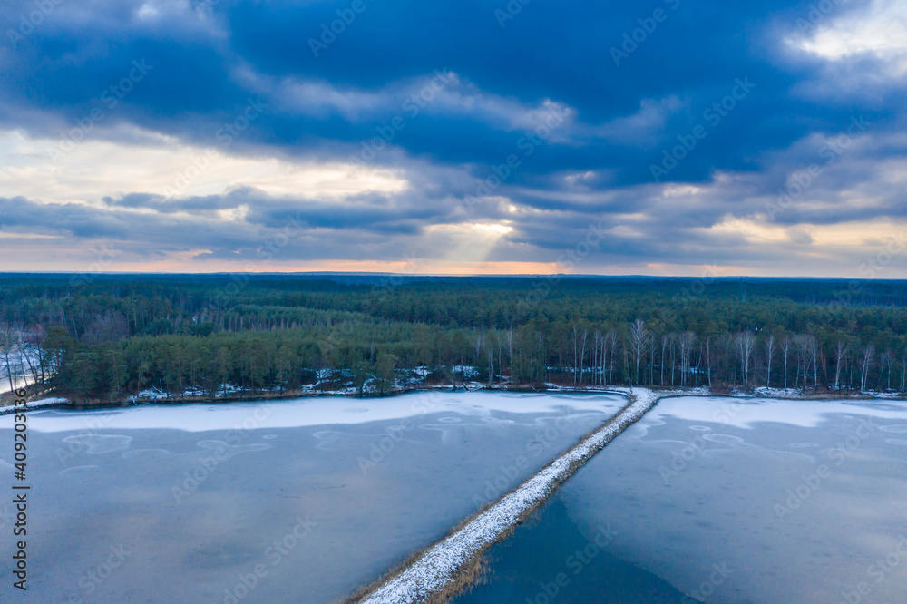Zimowy wieczór nad stawem hodowlanym. Widok z drona. Zimowy wieczór nad stawem hodowlanym. Widok z drona.