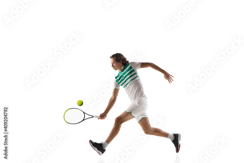 Attented. Young caucasian professional sportsman playing tennis isolated on white background. Training, practicing in motion, action. Power and energy. Movement, ad, sport, healthy lifestyle concept. © master1305