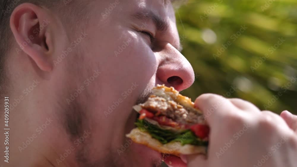 Bearded man is eating a hamburger. Junk food. unhealthy eat habits. Bearded man is eating a hamburger. Junk food. unhealthy eat habits.