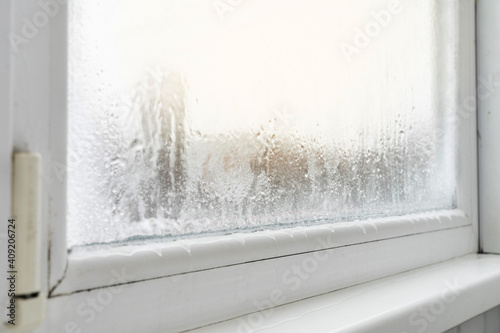 Close up of a defective plastic window with condensation and freezing inside. Poor ventilation, high humidity and temperature differences.