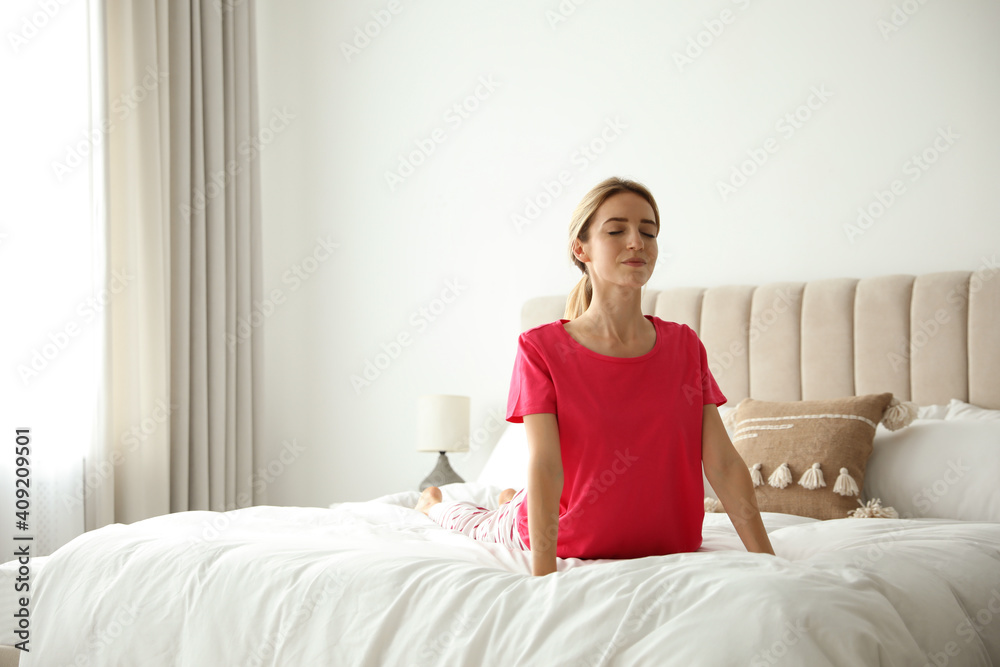 Young woman doing gymnastics on bed at home. Morning fitness Young woman doing gymnastics on bed at home. Morning fitness