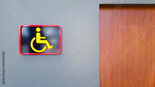 Toilet sign on gray or grey wall for reserved disable people use this washroom only with copy space. Public restroom or Cripple on wheel chair. Design and Shape of object. photo
