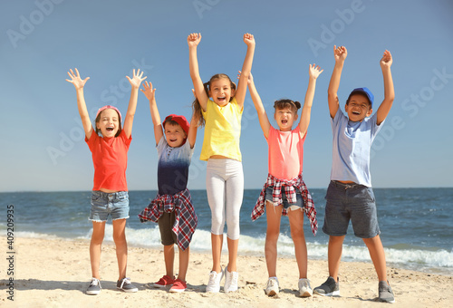 Group of happy children at sea beach on sunny day. Summer camp