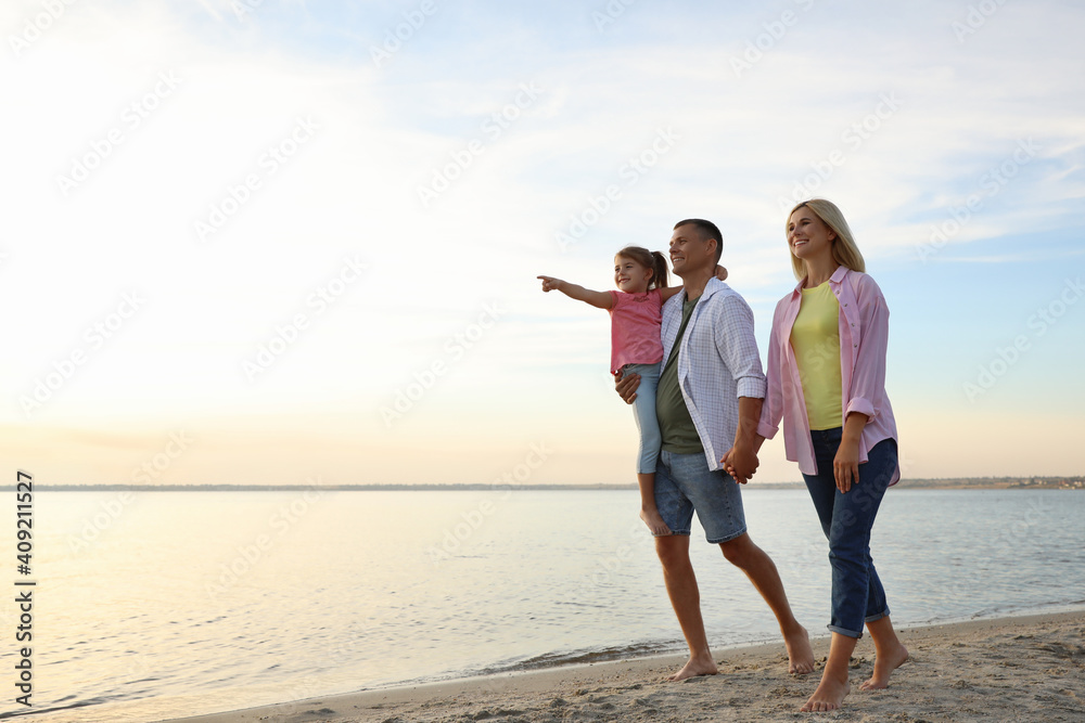 Happy parents with their child on beach, space for text. Spending time in nature