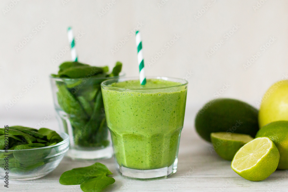 Healthy green smoothie with spinach, avocado, lime, pinapple on wooden table Healthy green smoothie with spinach, avocado, lime, pinapple on wooden table