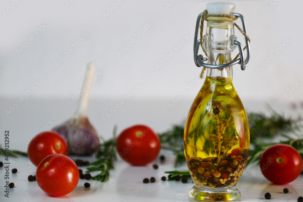 Fresh olives and oil in bottle with rosemary on white background with scattered cherry tomatoes end spicies, top view. Organic olive oil concept Fresh olives and oil in bottle with rosemary on white background with scattered cherry tomatoes end spicies, top view. Organic olive oil concept