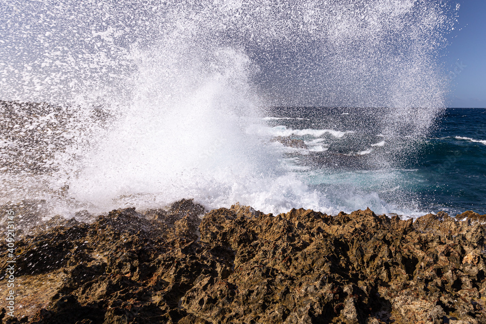 waves against a rocky beach; Aruba
