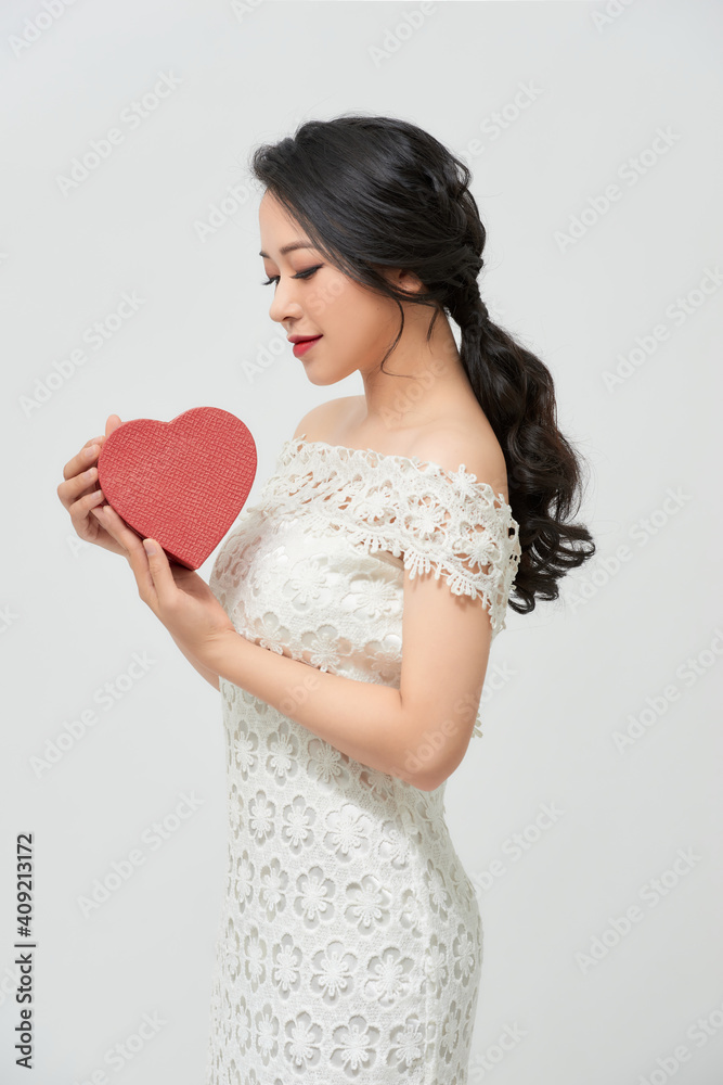 Studio portraits with beautiful bride isolated on white background. She is holding red heart. Studio portraits with beautiful bride isolated on white background. She is holding red heart.