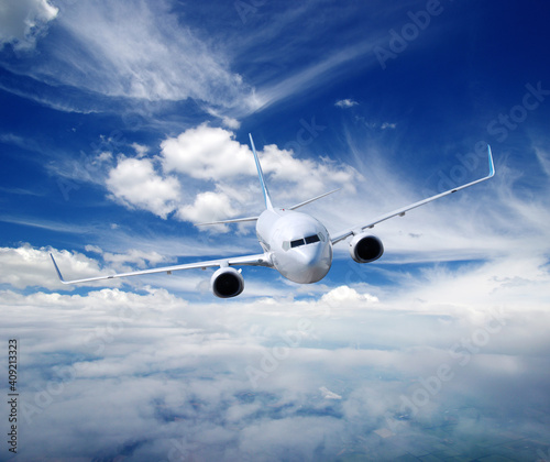 Landscape with airplane is flying in the blue sky and white clouds.