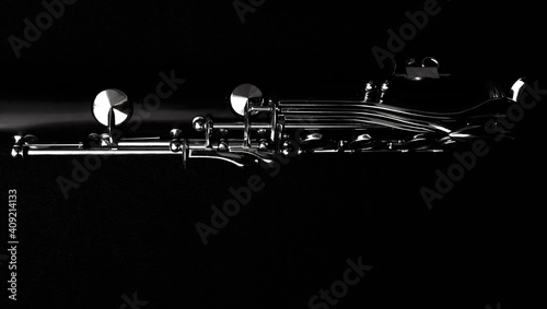 un clarinetto nella penombra con i suoi tasti illuminati photo