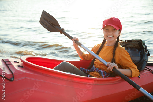 Happy girl kayaking on river. Summer camp activity