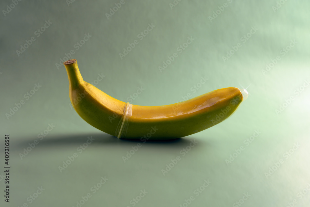 banana in a condom on a light gray background banana in a condom on a light gray background