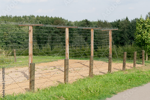Model of a wooden fence with barbed wire along the perimeter of the protected area.