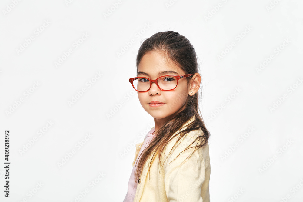 Beautiful Latin American little girl in stylish red glasses on light gray background