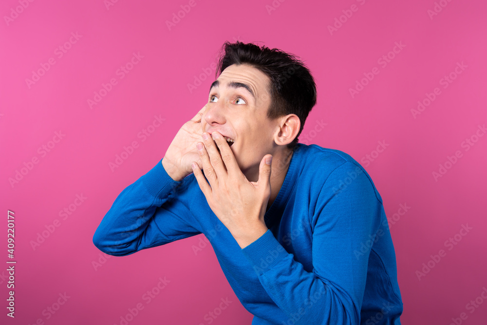 A young man gestures with his hands. Pink background. Consent and denial. Good and bad. A young man gestures with his hands. Pink background. Consent and denial. Good and bad.