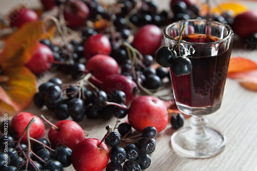 Canvas Print Homemade tincture of black chokeberry and red apples