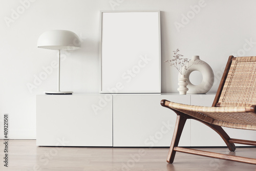 Blank picture frame mockup on white wall. White living room design. View of modern scandinavian style interior with chair. Home staging and minimalism concept photo