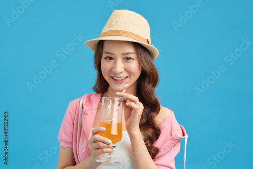 Modern girl drinking orange juice. Isolated portrait.