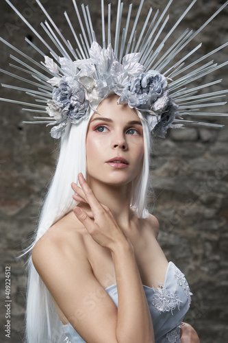 Portrait of winter queen. Attractive young woman in dress, veil, silver flower crown