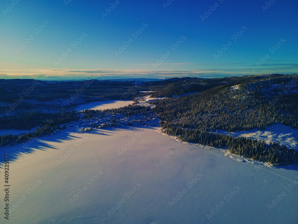Frozen lake in the Norwegian wilderness, covered in undisturbed snow on a bright sunny day. Aerial photo. Frozen lake in the Norwegian wilderness, covered in undisturbed snow on a bright sunny day. Aerial photo.