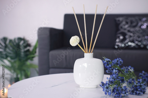 luxury aroma scented reed diffuser ceramic vase is used as room freshener and decoration items on the white marble table with bouquet of flowers in the living room to creat romantic valentine ambient
