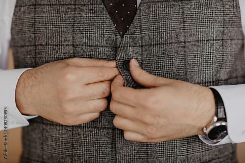Grooms morning preparation. Handsome man getting dressed and preparing for the wedding, businessman checking time on his wrist watch, man putting clock on hand, groom getting ready in the morning