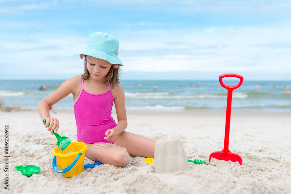 Happy child girl playing with sand at the beach in summer Happy child girl playing with sand at the beach in summer