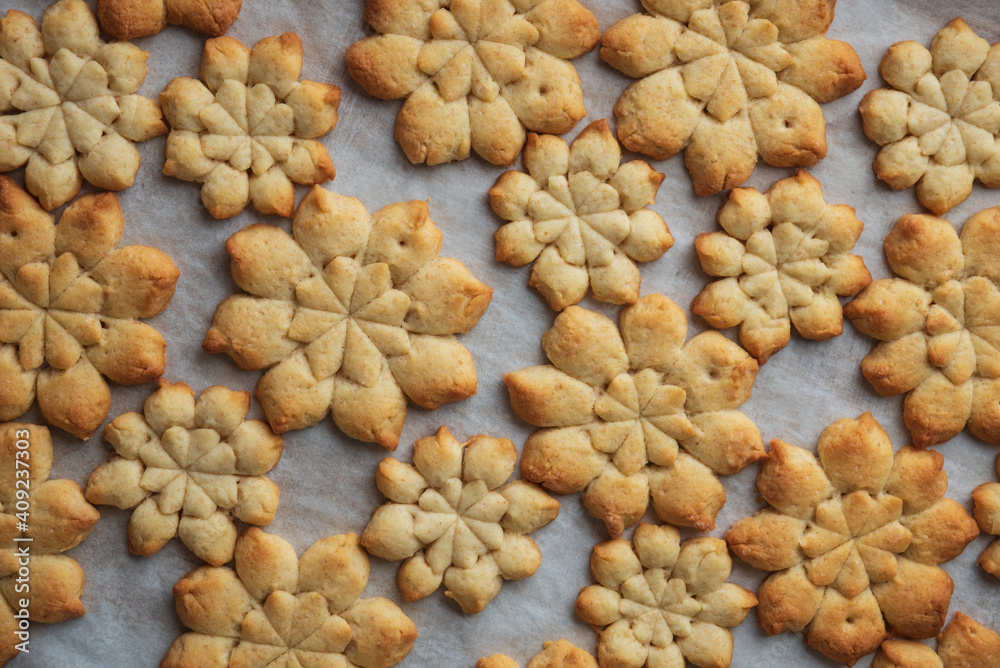 Close-up Christmas snowflakes gingerbread cookies on baking sheet. New Year and Christmas celebration concept. Soft focus. Close-up Christmas snowflakes gingerbread cookies on baking sheet. New Year and Christmas celebration concept. Soft focus.