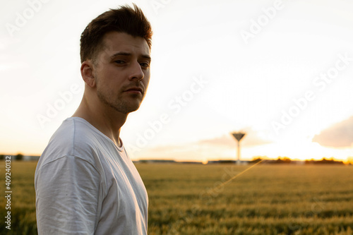 Young white european boy with blonde hair portrait with field behind