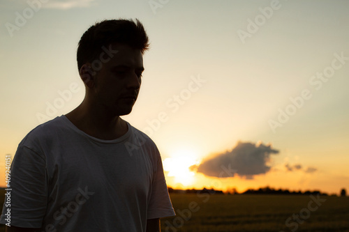 White european boy with sky behind in sunset shadow