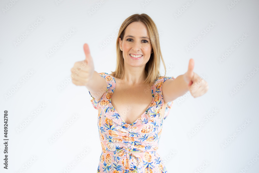 Young happy cheerful woman in casual dress showing thumbs up over white background. Young happy cheerful woman in casual dress showing thumbs up over white background.