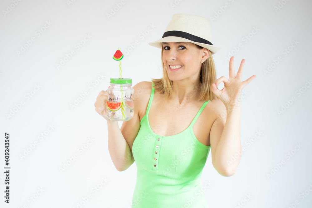 Happy young woman holding cold drink showing okay sign with fingers isolated over white background Happy young woman holding cold drink showing okay sign with fingers isolated over white background