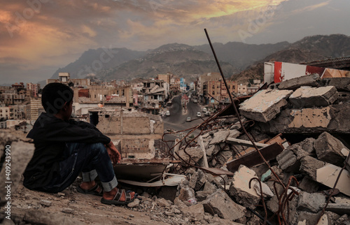 Fotografering A child from Taiz City sits on the ruins of his ruined home because of the war on city-Yemen