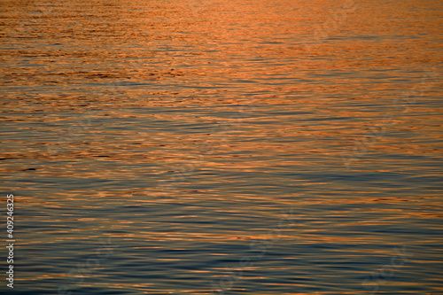 Gentle waves with reflection of sunset on the sea