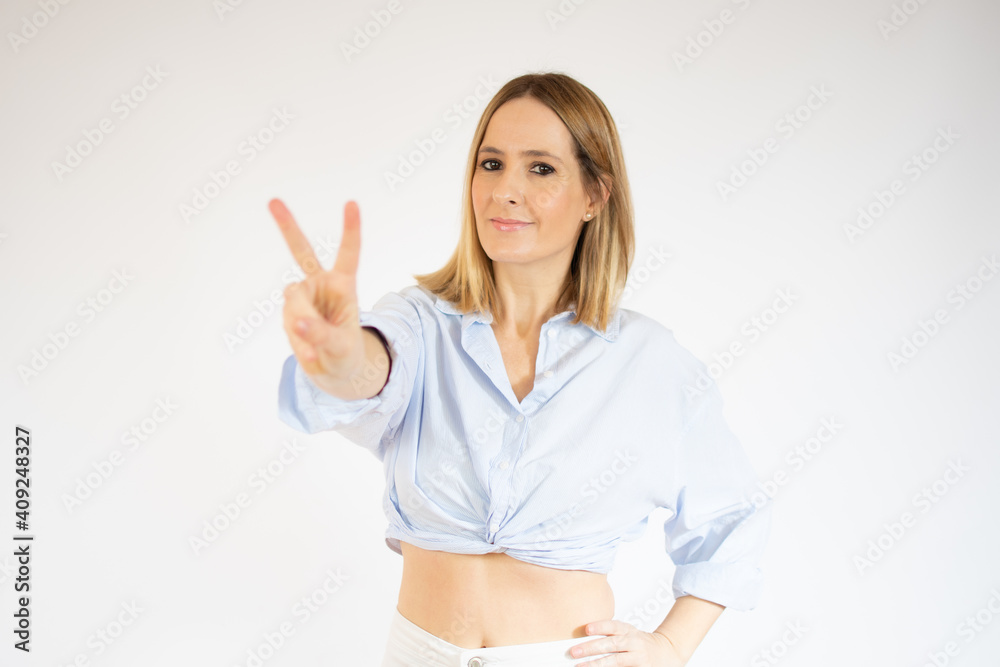 Portrait of a smiling happy woman showing victory sign and looking at camera isolated over white background Portrait of a smiling happy woman showing victory sign and looking at camera isolated over white background