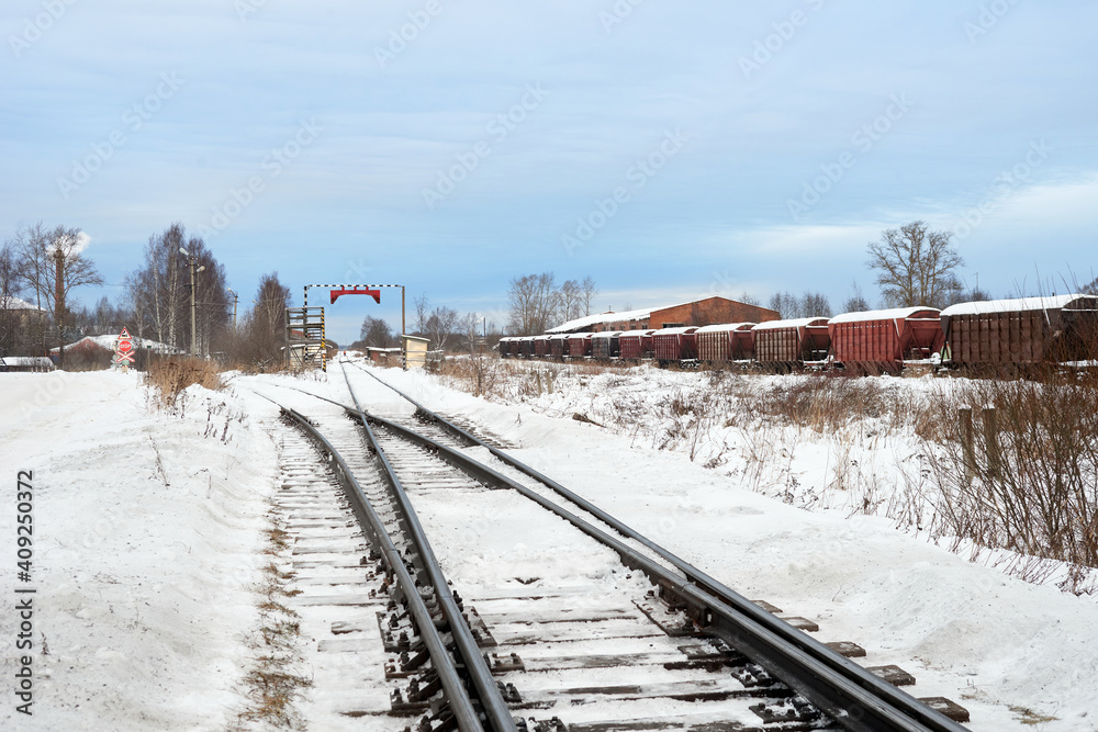Railroad tracks in winter time. Railway infrastructure. Steel railway for trains in snow. Railway tracks with crossing