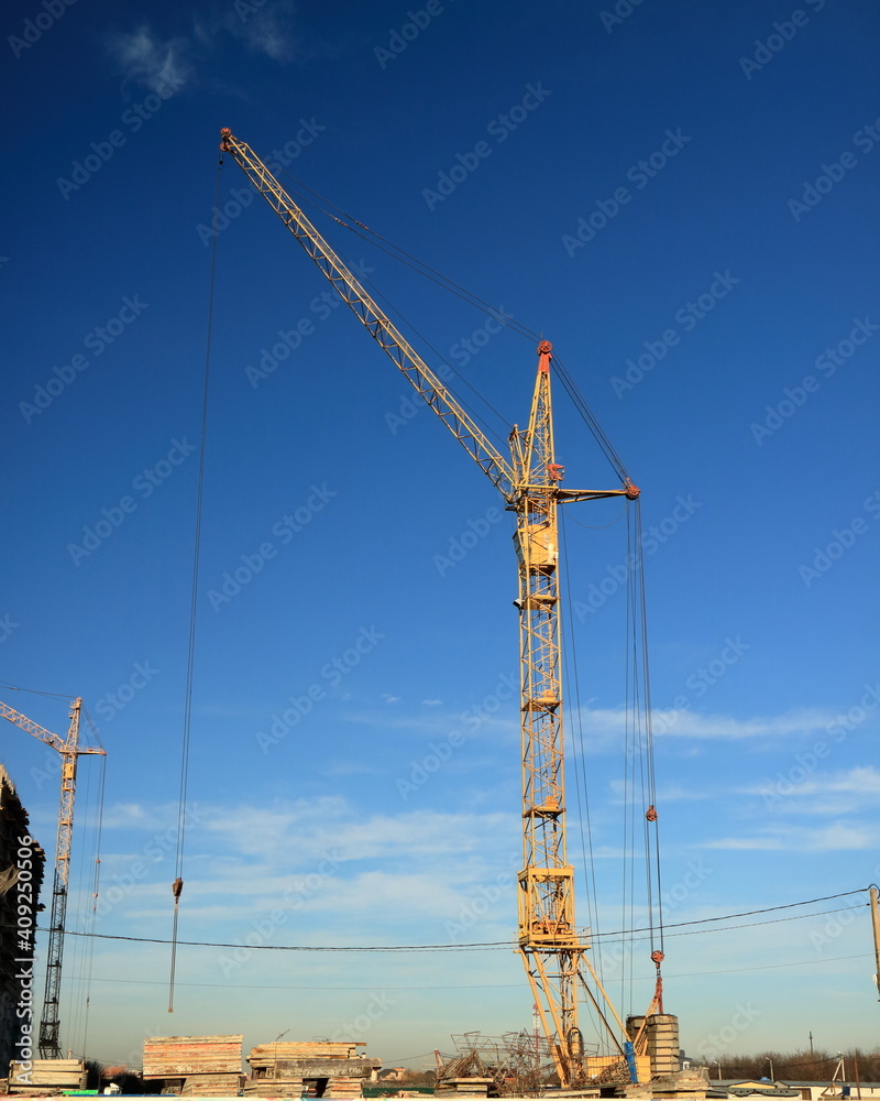 Tower cranes are working on the construction of a new house. Lifting crane. Tower cranes are working on the construction of a new house. Lifting crane.
