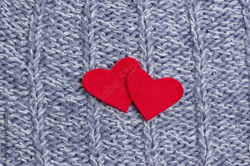 Textile background. Two red hearts on the soft knitted blanket. Valentines day concept.
