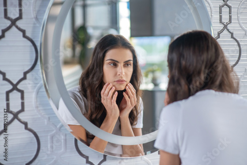 Foto Woman looking at her reflection in the mirror