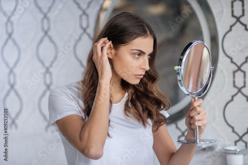 Woman looking at the small portable mirror