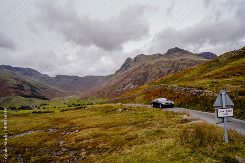 Black convertible sports car driving through mountain pass of La