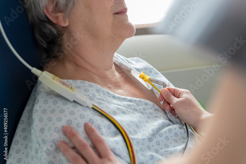 a nurse places electrodes on a patient's chest photo