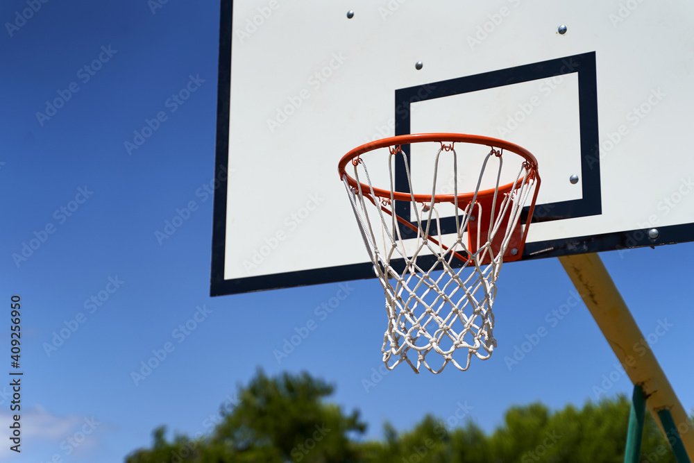 Outdoor basketball hoop or goal on blue sky background.