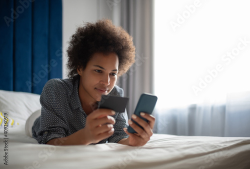 Black woman entering credit card credentials in smartphone photo
