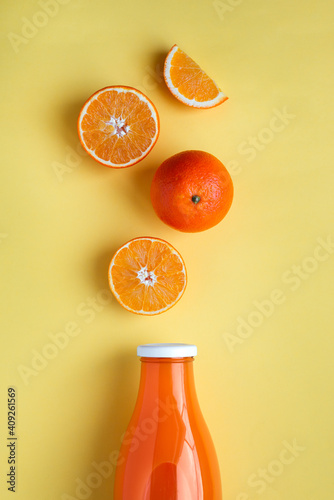 Freshly squeezed orange juice on yellow background photo