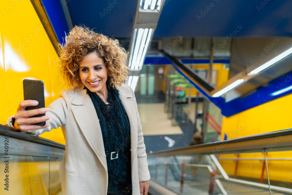 woman going up the escalator while using her smartphone woman going up the escalator while using her smartphone
